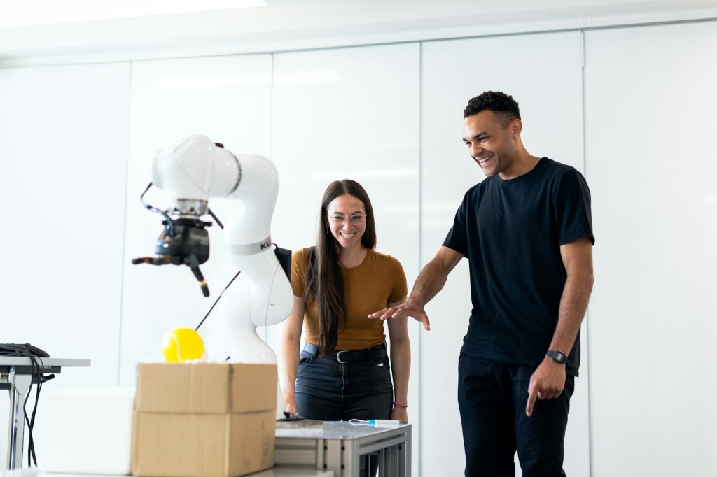 Due persone collaborano in un ambiente di lavoro tecnico con strumenti digitali.